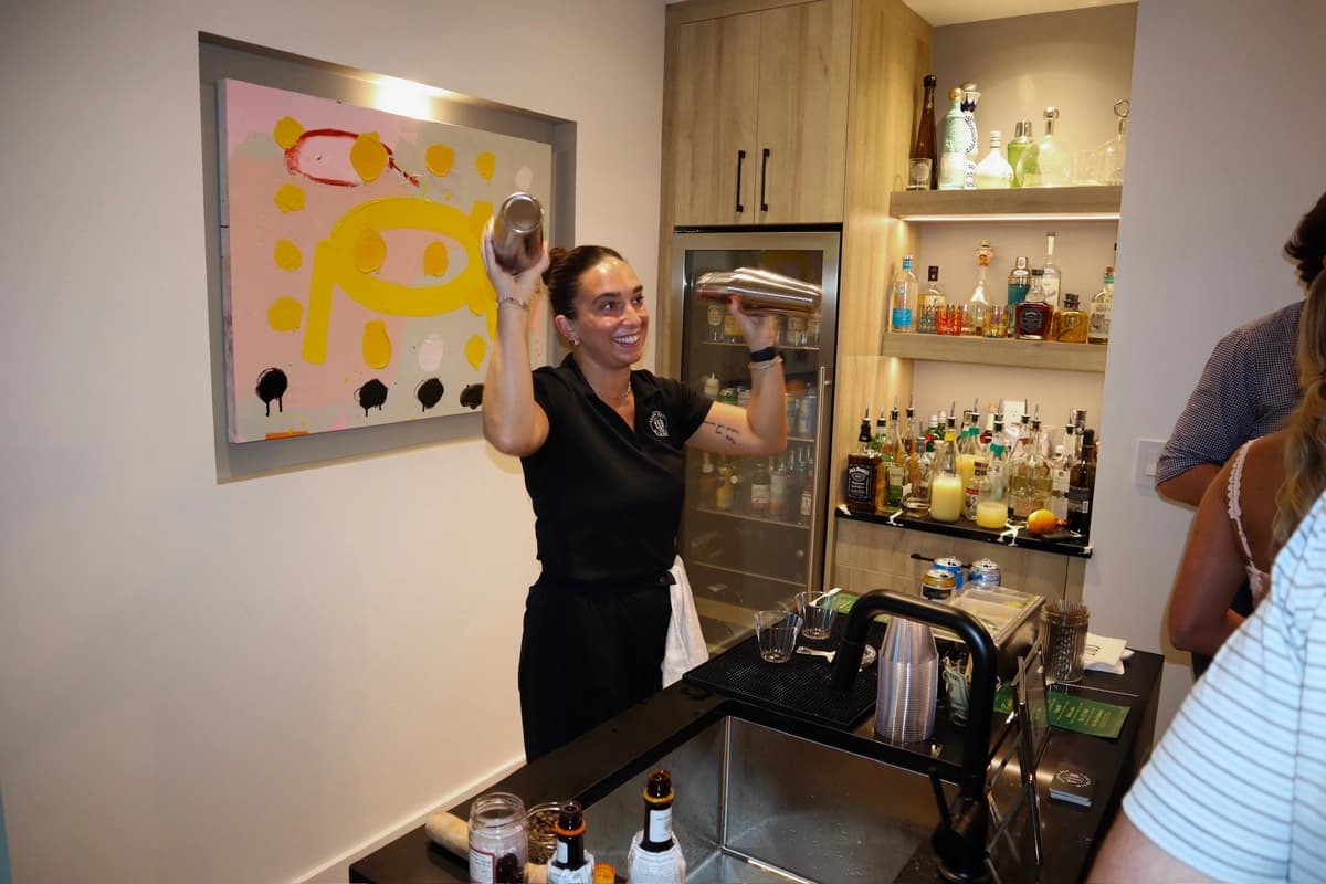 Bartender shaking cocktail at home bar during private event