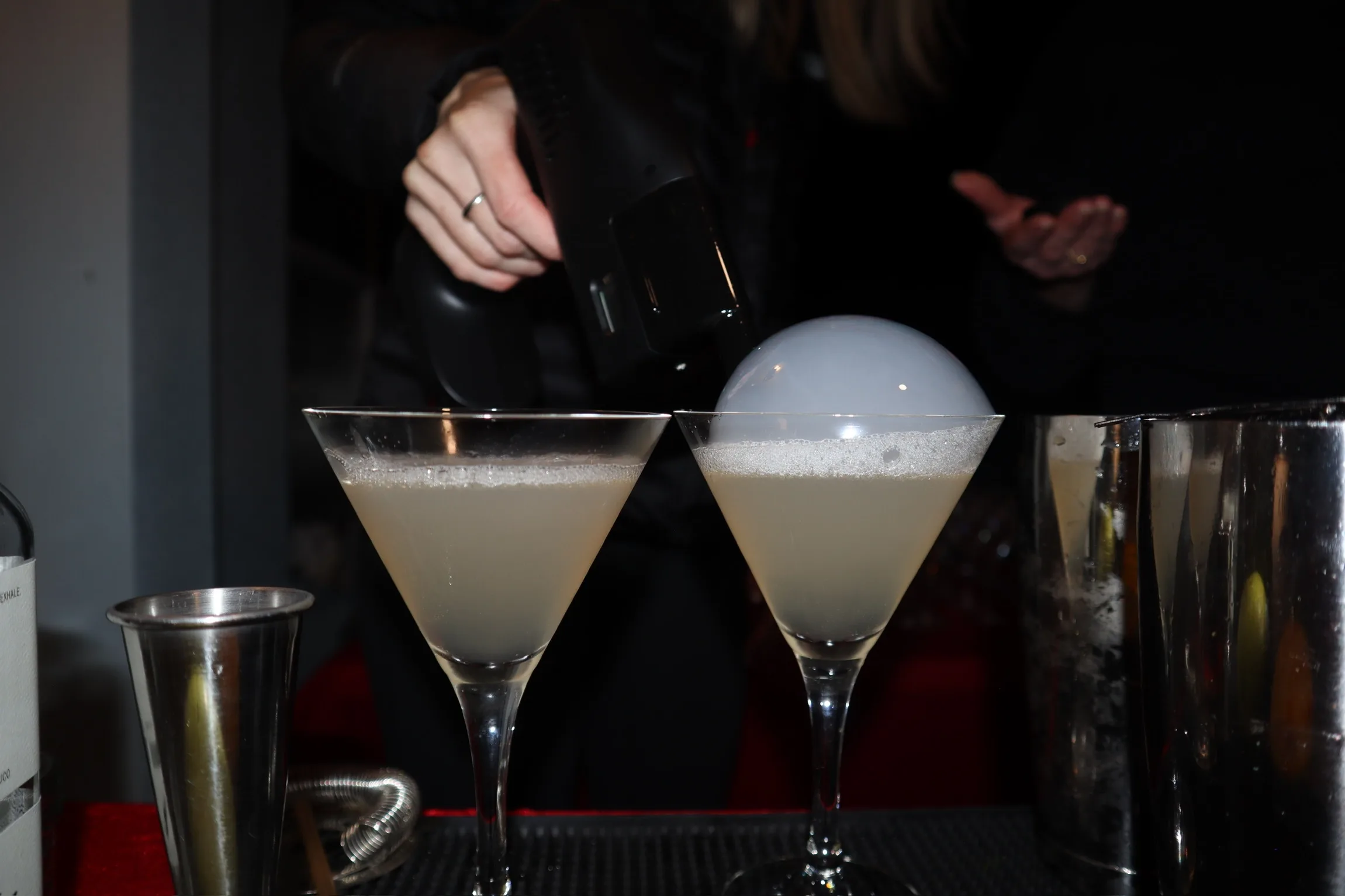 Two espresso martinis with warm ambient bar lighting