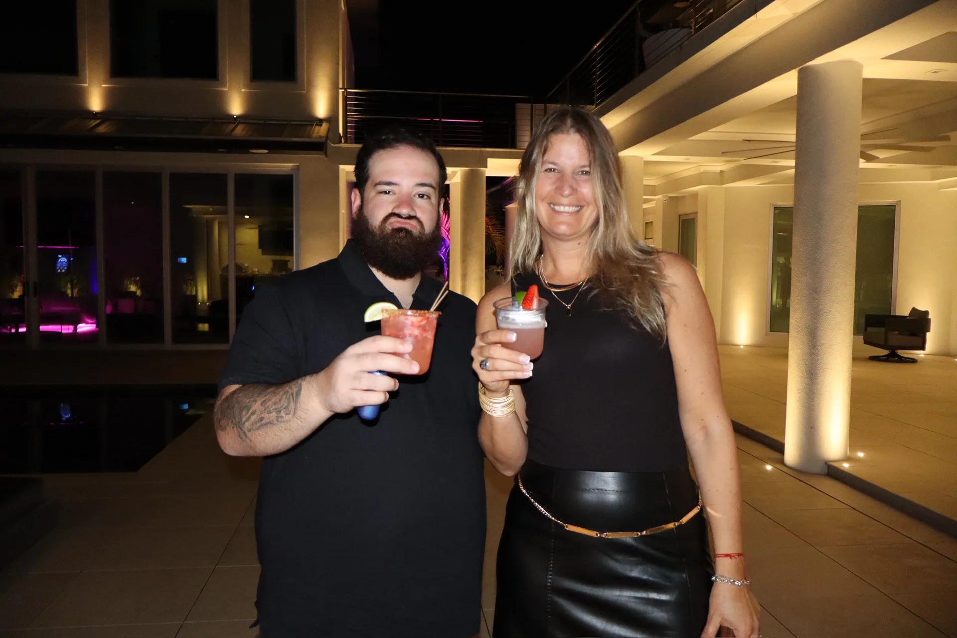 Guests holding craft cocktails at upscale rooftop birthday party