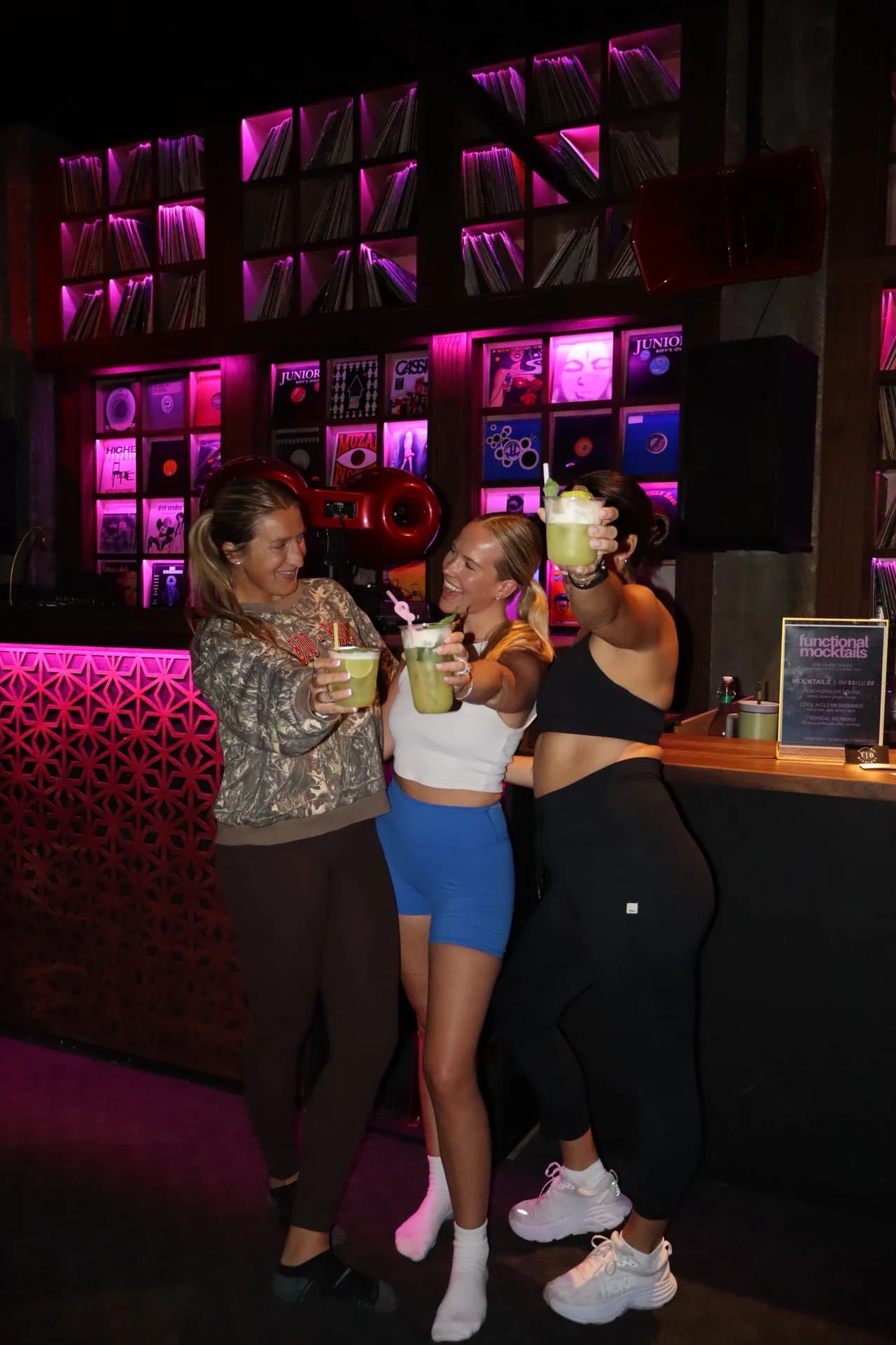 Three guests toasting functional mocktails at the BODYROK studio bar