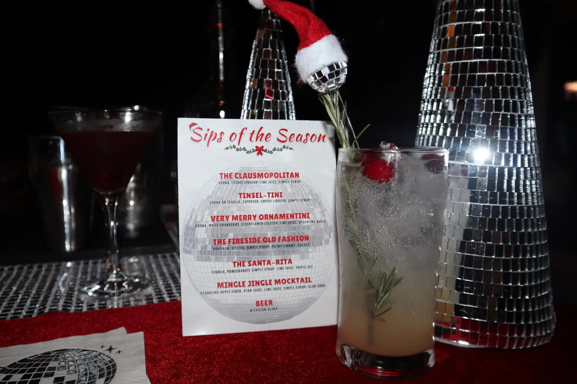 Custom Sips of the Season cocktail menu with disco ball and Christmas decor