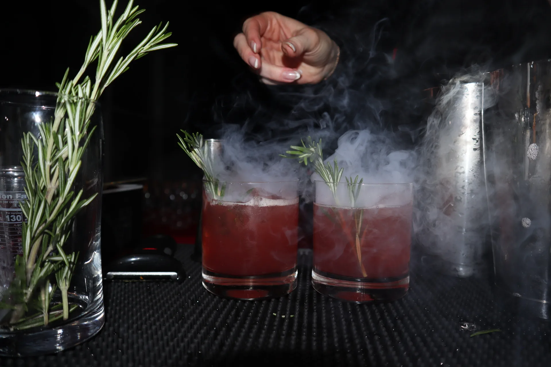 Smoked cranberry cocktails with rosemary garnish at Christmas party