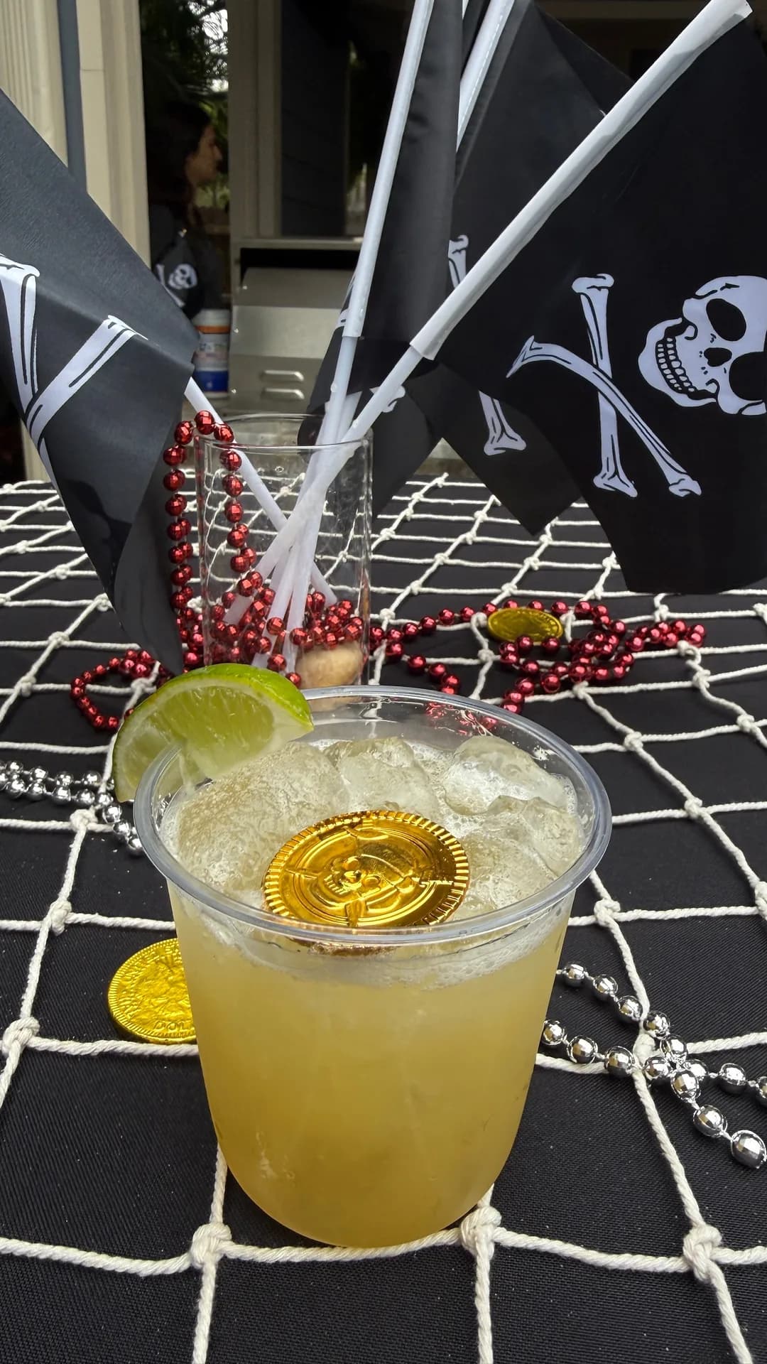 Lime cocktail with gold coins and pirate flags at Gasparilla party