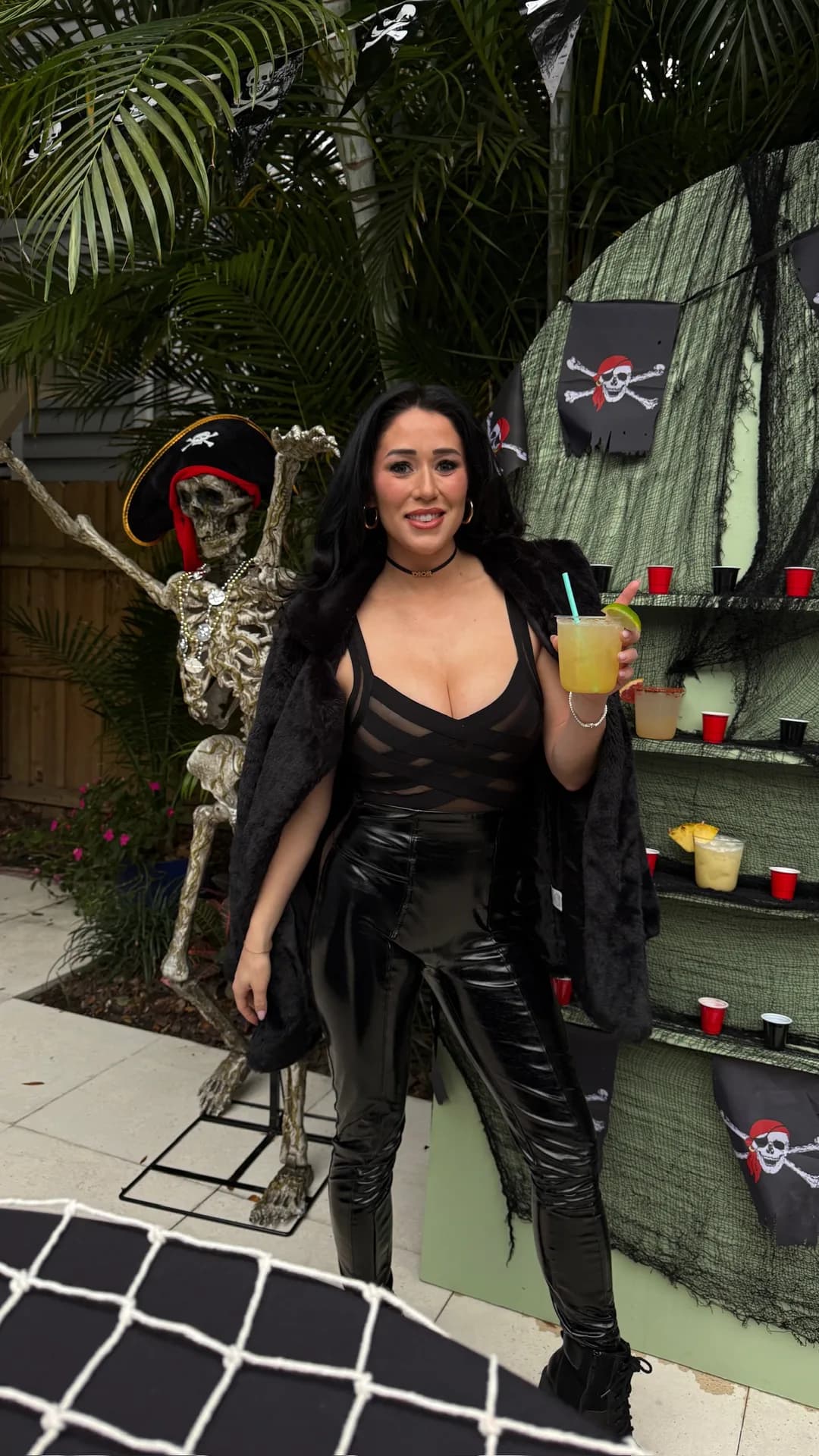 Guest in pirate outfit holding cocktail at Gasparilla party