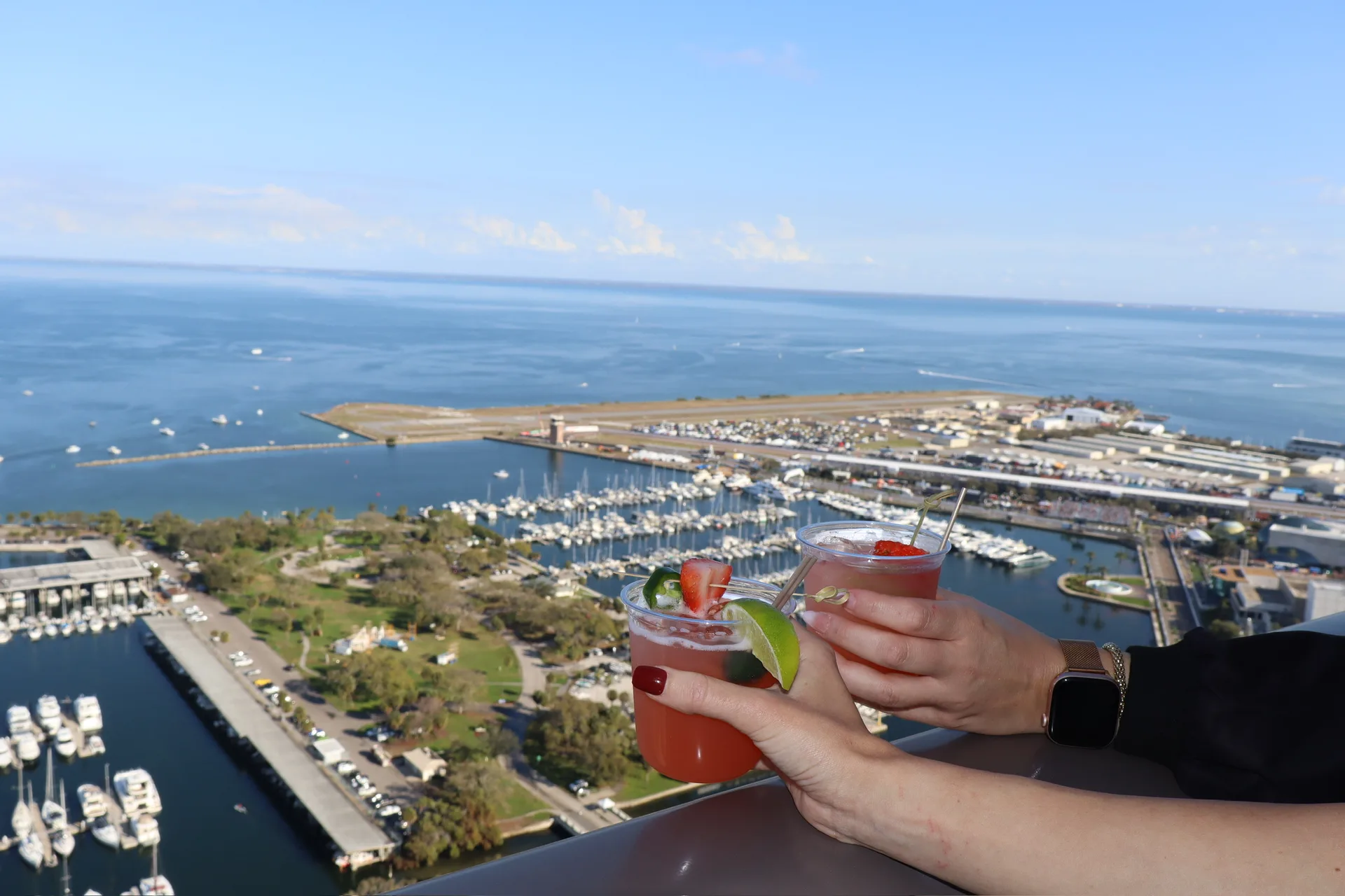 Cocktails cheersing with aerial marina and Tampa Bay view