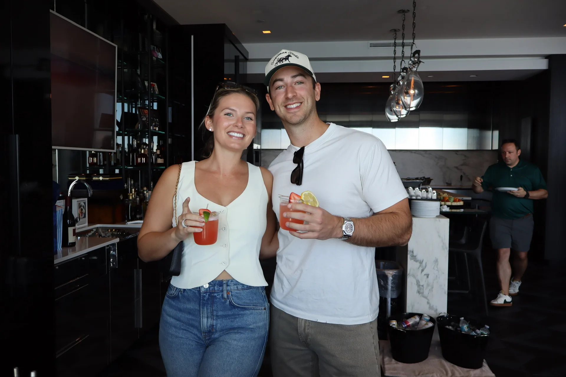 Couple posing with craft cocktails in highrise penthouse