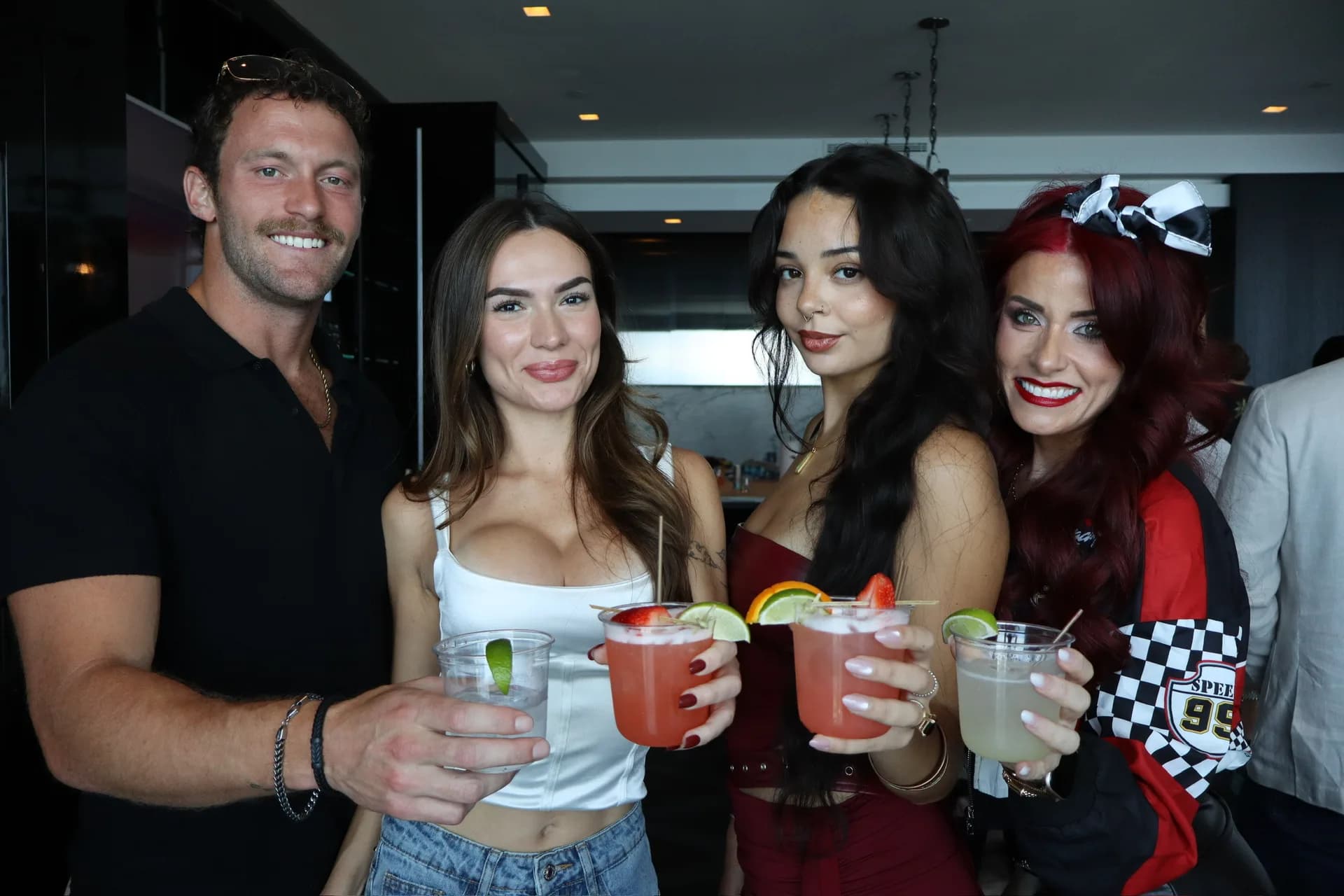 Friends in Grand Prix racing themed outfits toasting cocktails