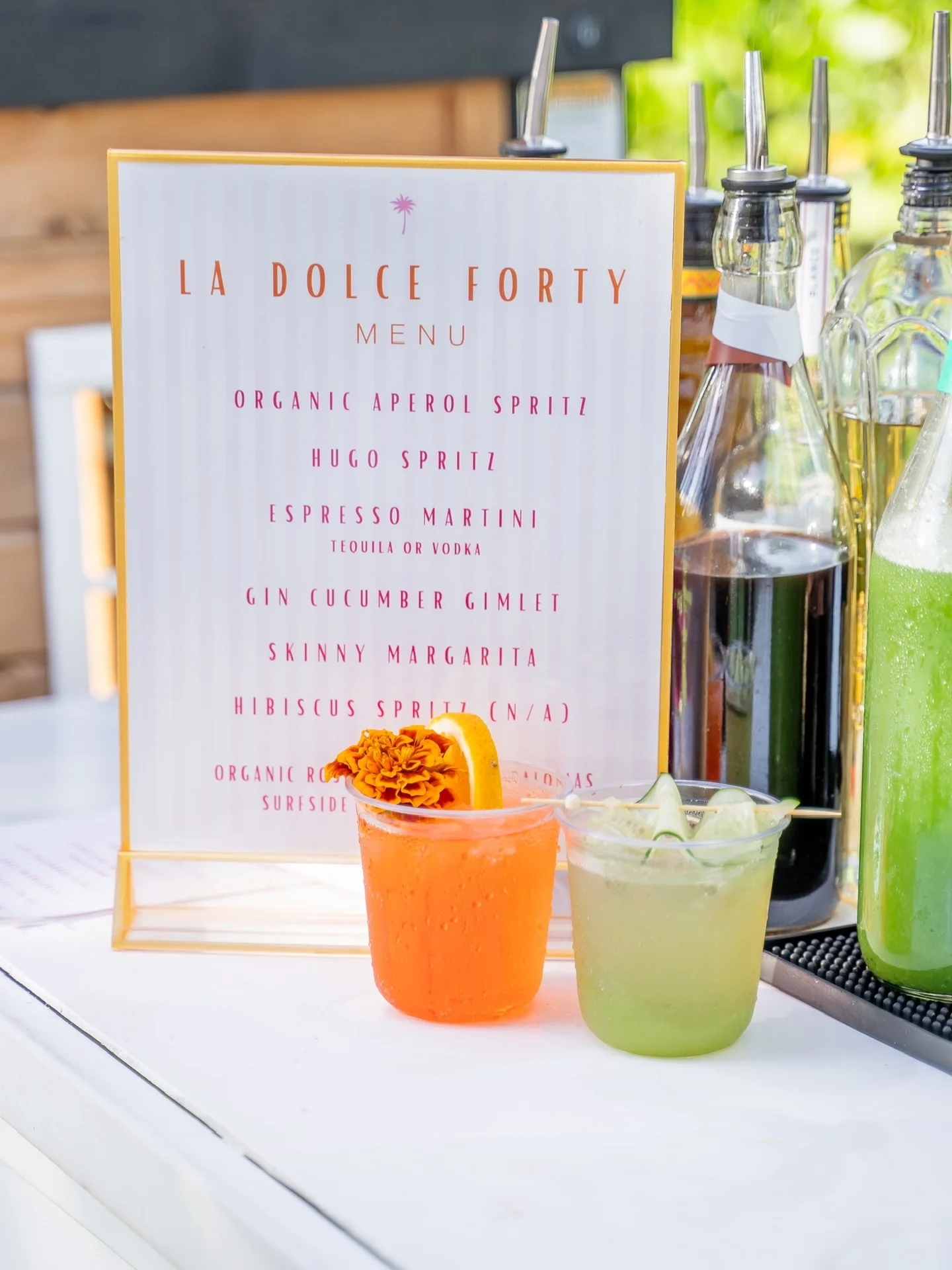 La Dolce Forty custom cocktail menu beside two spritzes at the bar