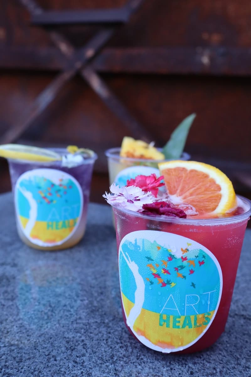 Pink and purple mocktail duo on concrete with rustic metal backdrop