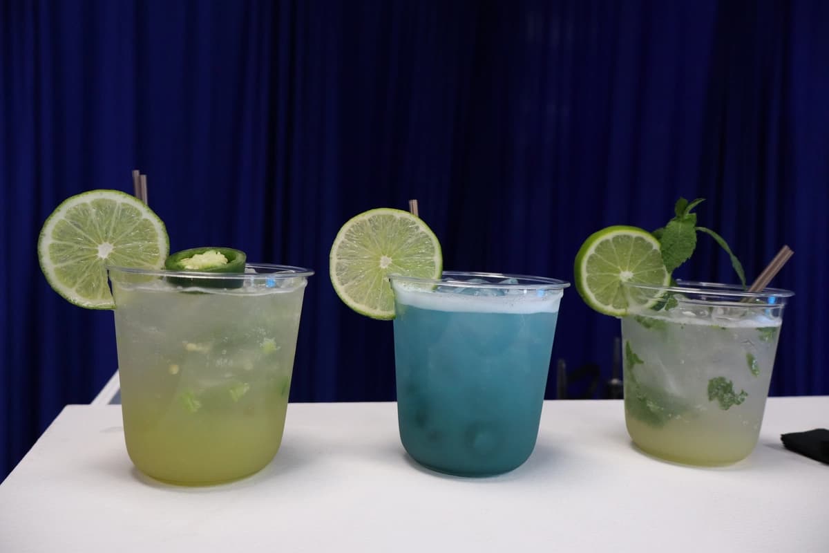 Three blue and green mocktails lined up at corporate event