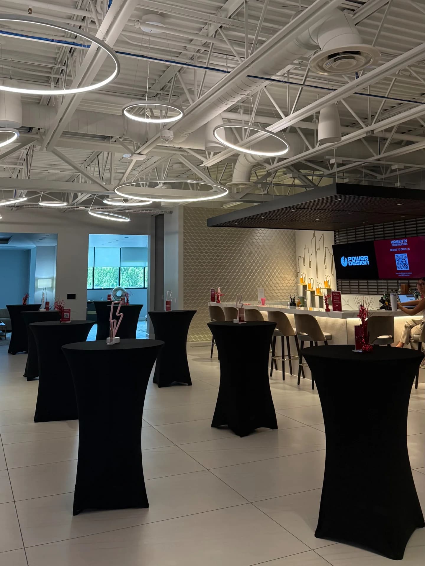 Corporate event space with black cocktail tables and full TB Mixology bar setup