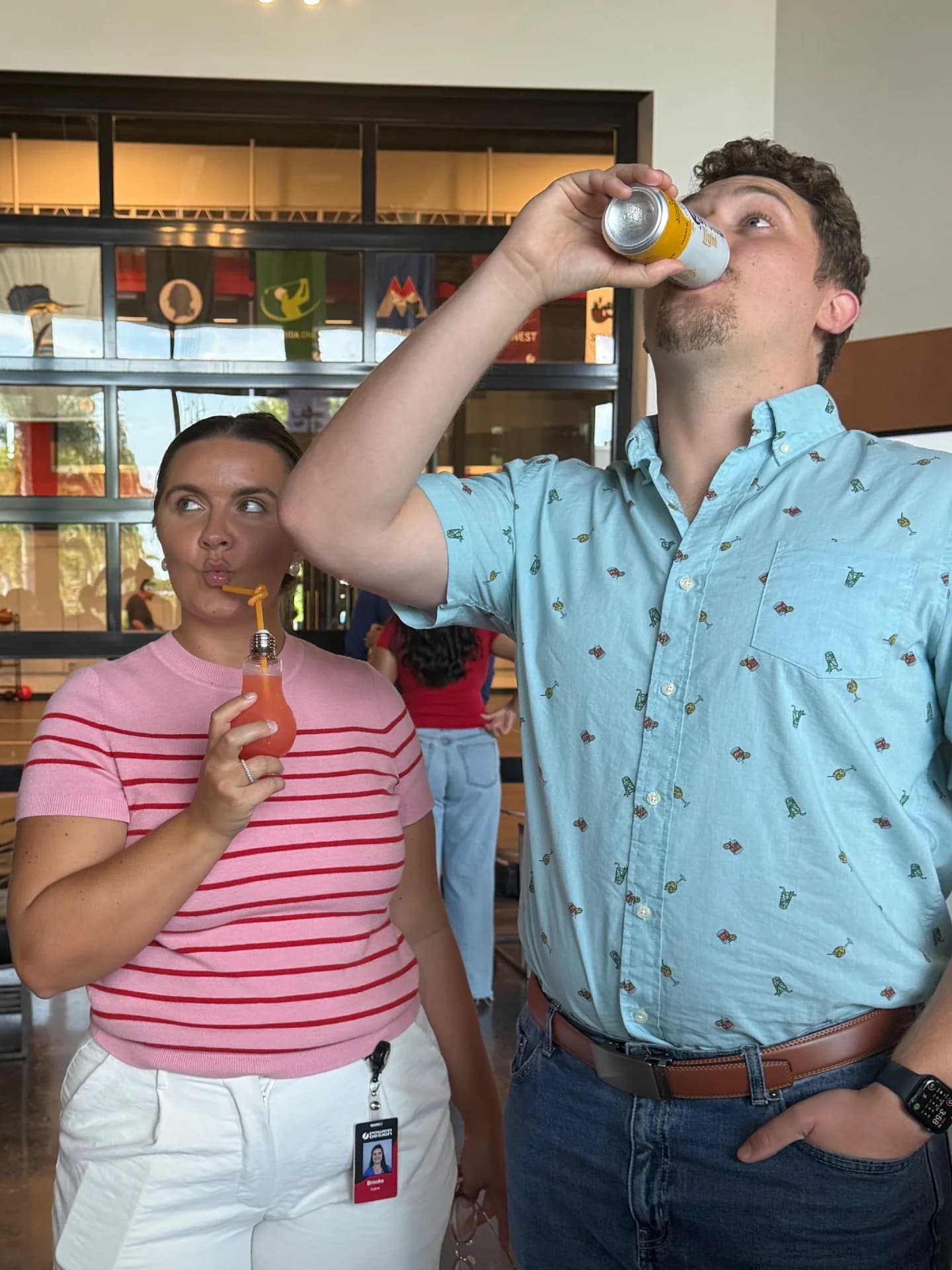 Two coworkers enjoying drinks in the office lounge at a corporate event