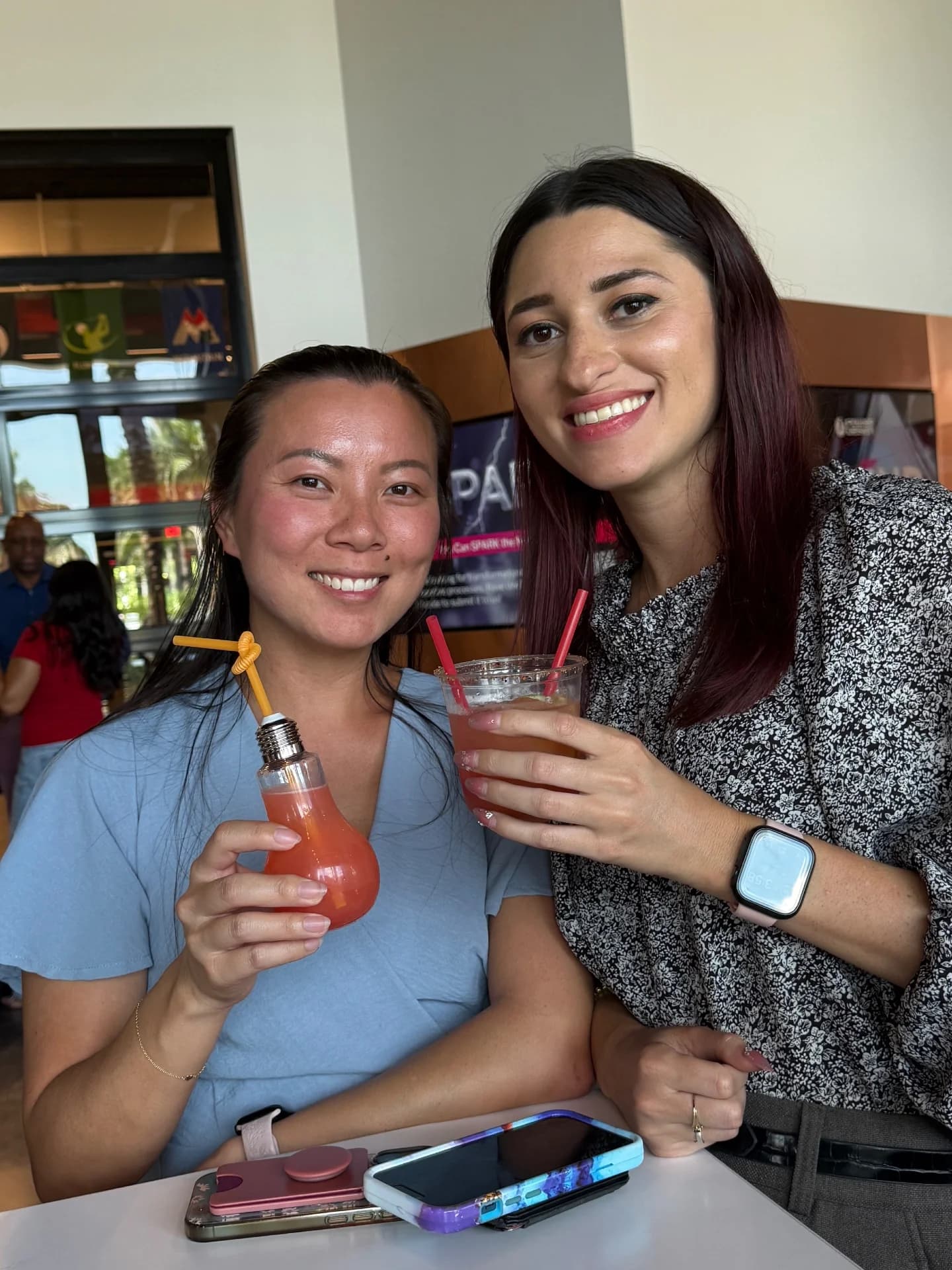 Two employees smiling with craft mocktails at a company event