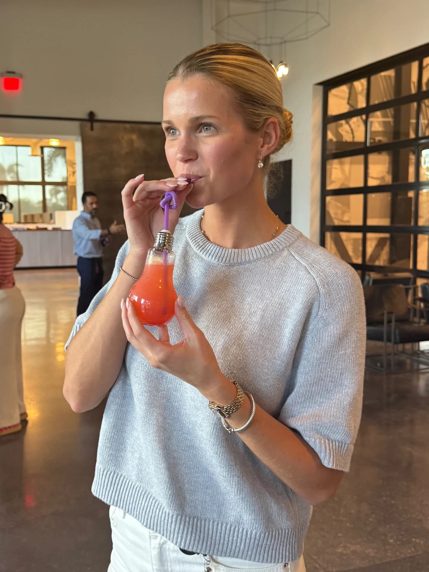 Employee sipping a mocktail from a light-bulb glass at a corporate event