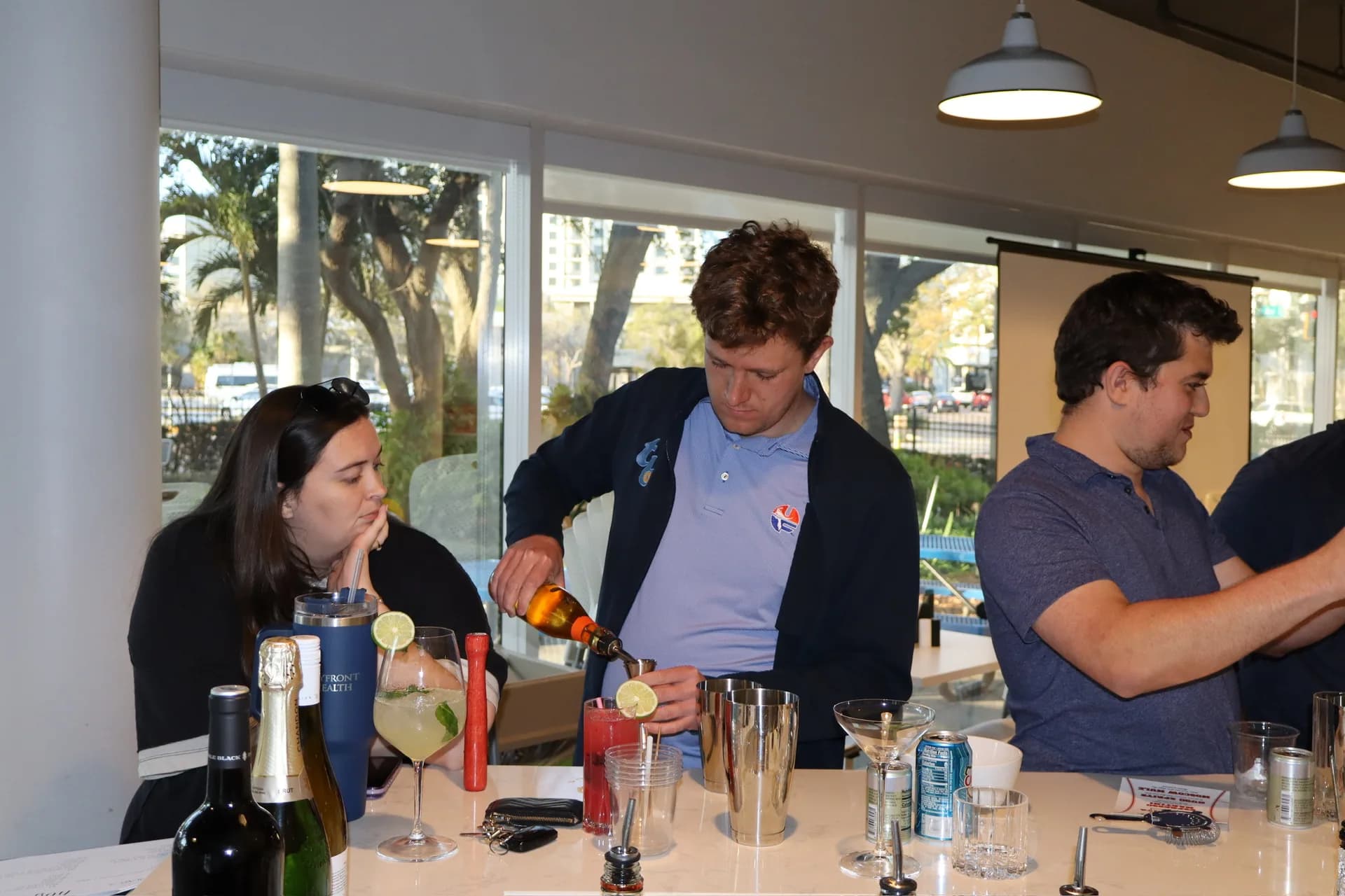 Rays staff member pouring from jigger into shaker at cocktail class