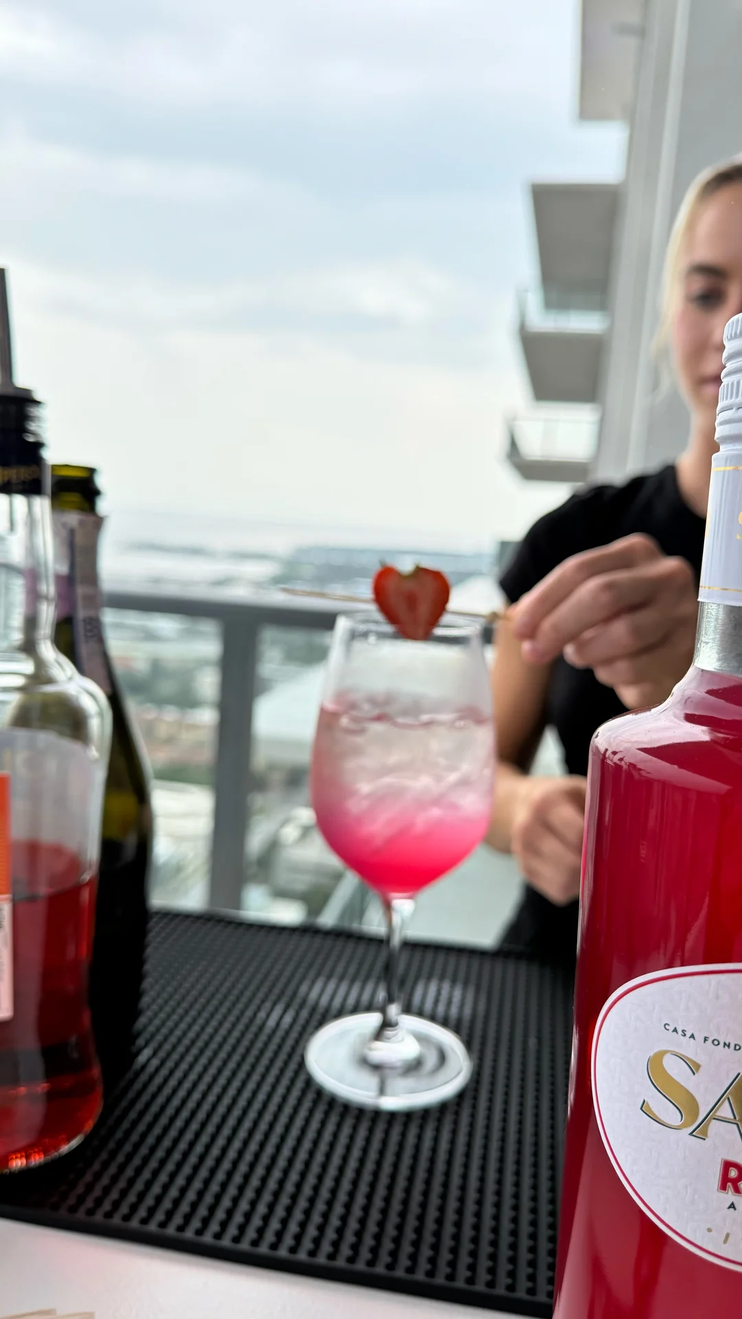 Sarti Rosa strawberry spritz served in a wine glass on the bar mat