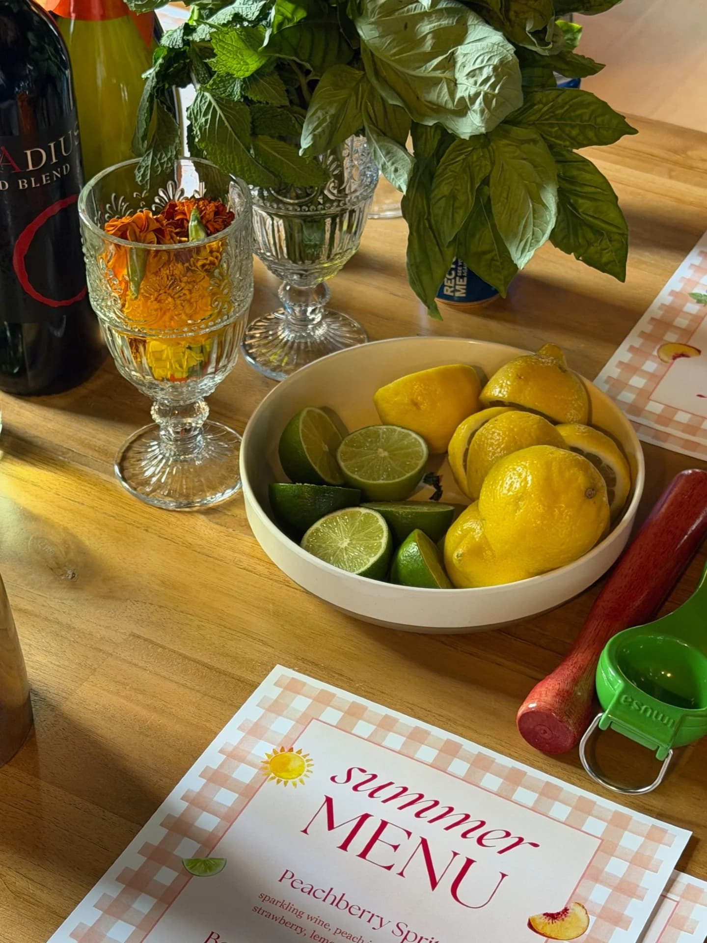 Summer cocktail menu card beside a bowl of lemons and limes