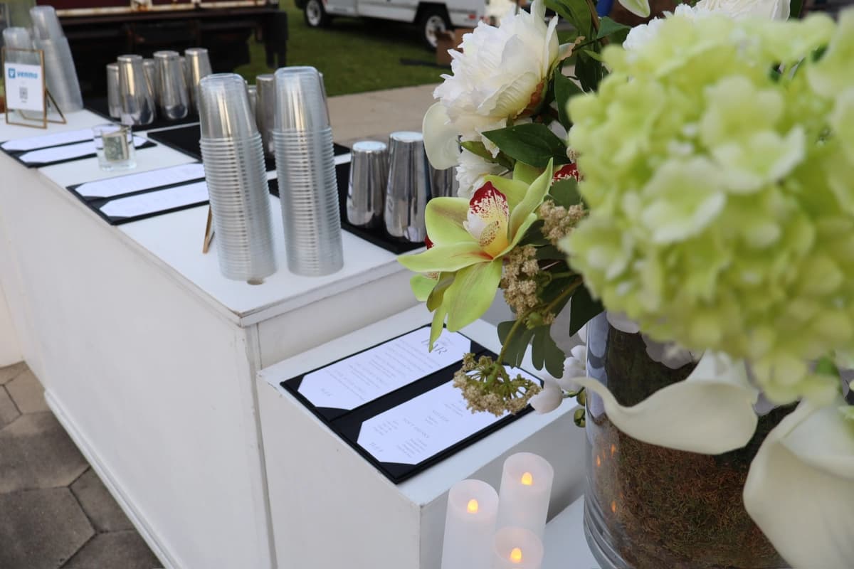 Wedding bar with cocktail menu display and orchid arrangement