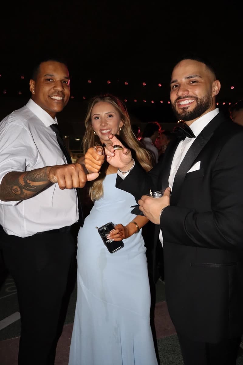 Wedding guests posing with fist bump under string lights
