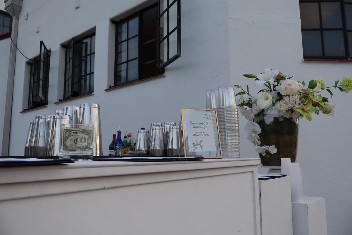 Wedding mobile bar setup with floral arrangement and cocktail shakers