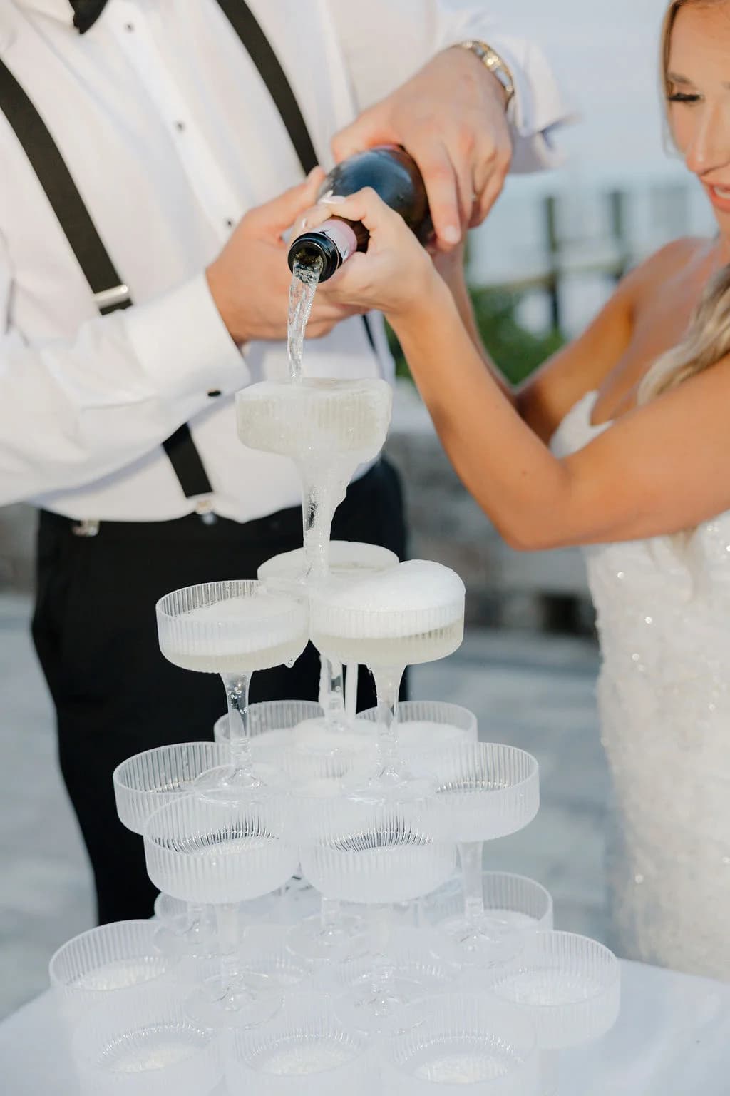 Champagne cascading down a stacked coupe tower at a wedding reception
