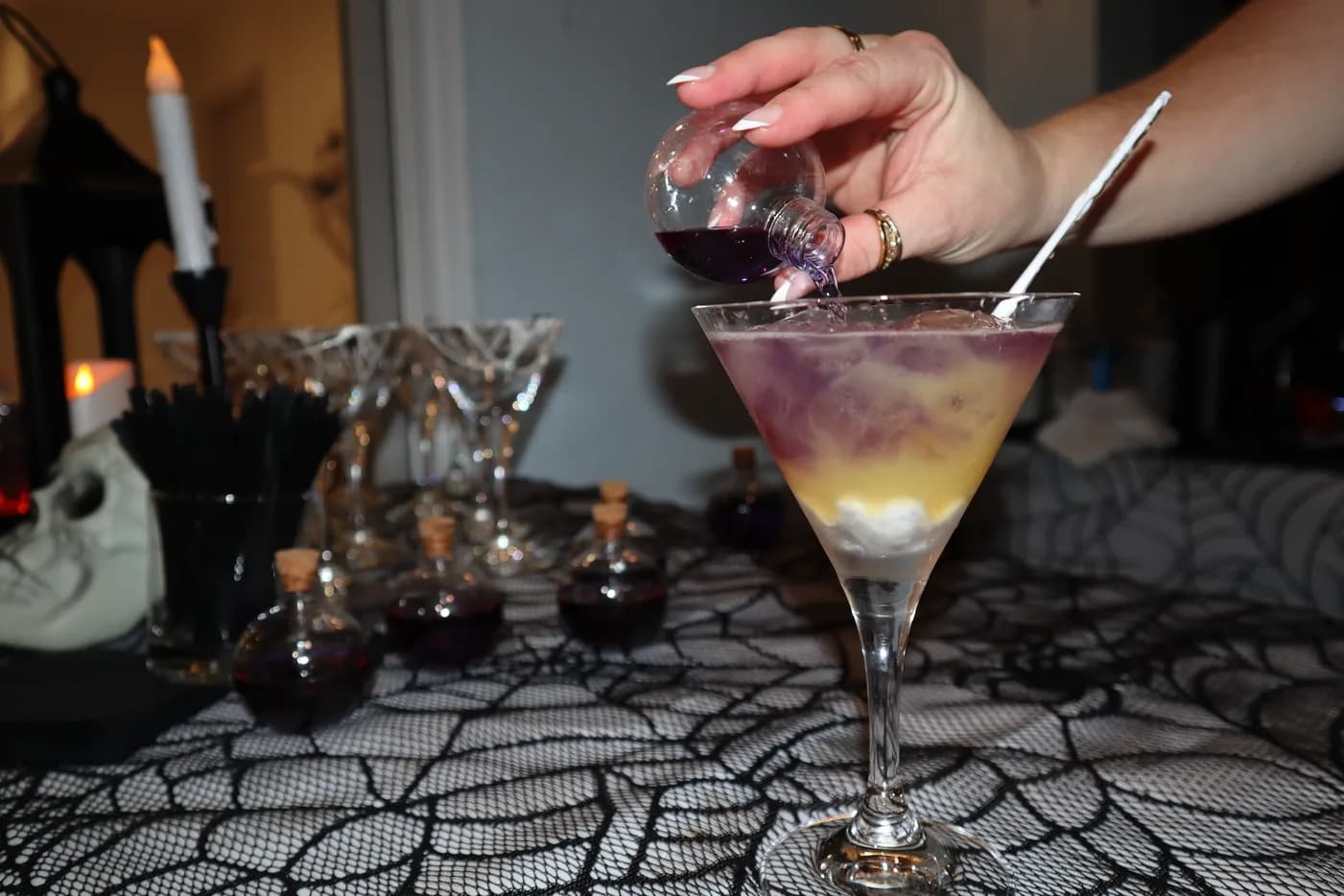 Layered purple martini being poured at a Halloween party