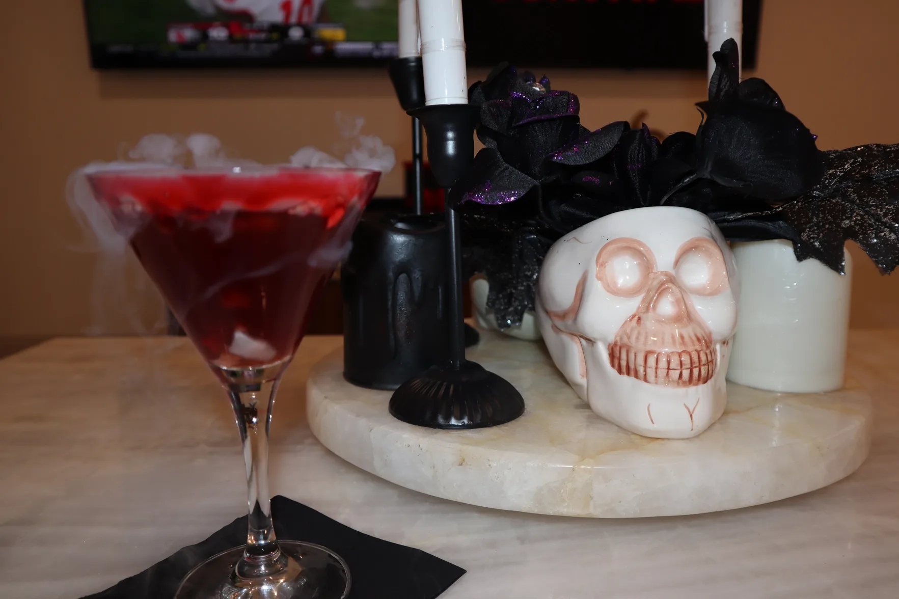Halloween-themed red martini with dry ice smoke and skull decor