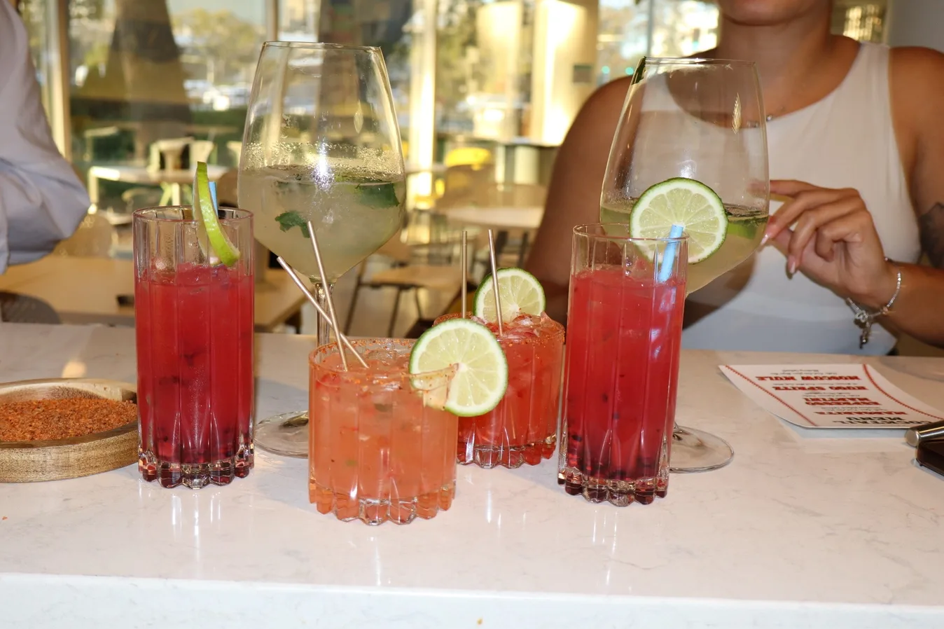 Colorful cocktail lineup with lime garnishes from a cocktail class