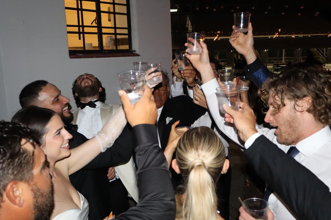 Wedding party raising drinks in a formal toast at the reception